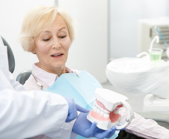 dentist showing a denture to a patient   