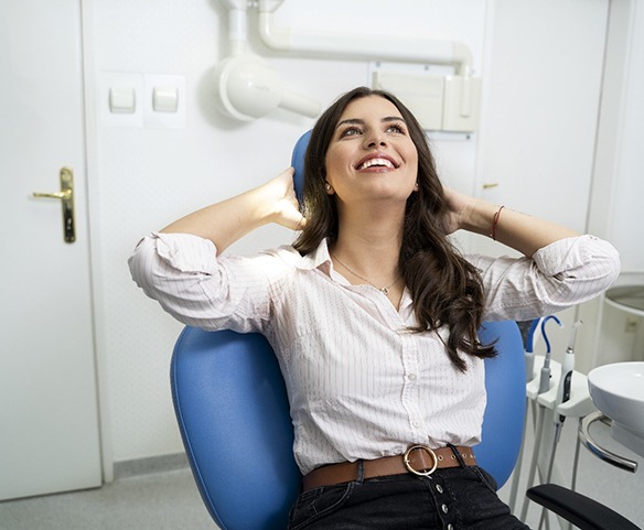 Smiling female patient casually sitting back in dental chair