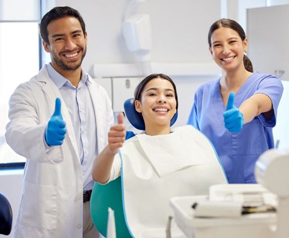 Patient and dental team making thumbs up gesture