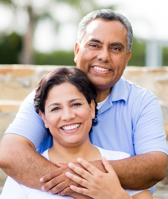 Man and woman smiling after tooth extractions