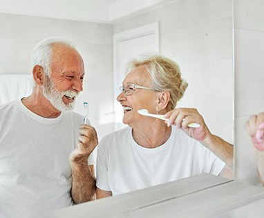 Man and woman brushing teeth together