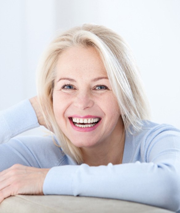 woman with implant dentures in Lincoln, NE grinning 