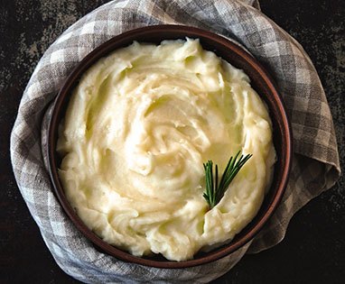 Bowl of mashed potatoes on table