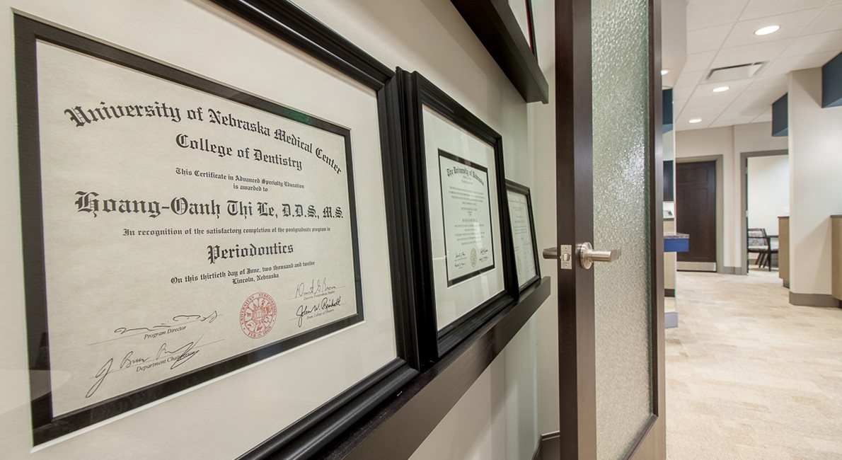 Periodontal degrees and certifications on office wall