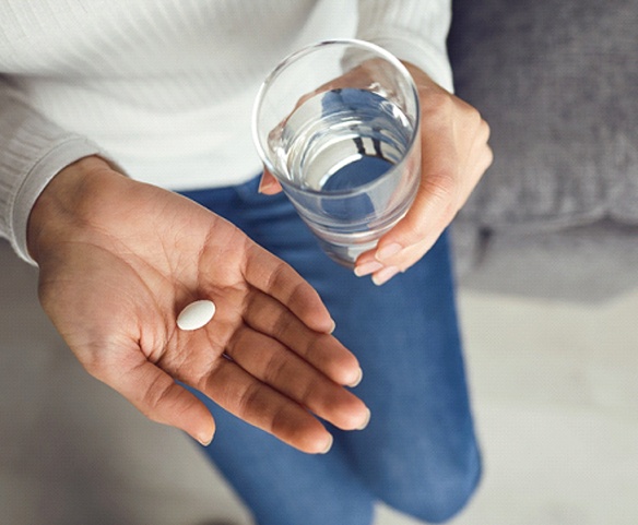 Person holding water and pill for oral conscious sedation