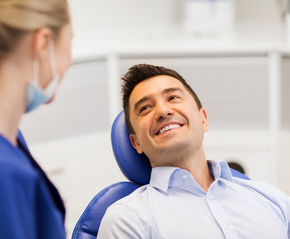 Man smiling at periodontist after full mouth reconstruction in Lincoln, NE