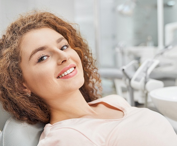 Woman laying back smiling after full mouth reconstruction in Lincoln, NE