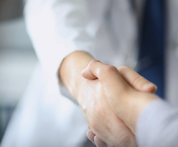 Shaking periodontist’s hand after full mouth reconstruction in Lincoln, NE