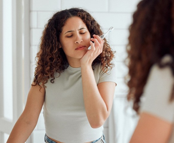 Woman experiencing oral discomfort from failed dental implant in Lincoln, NE