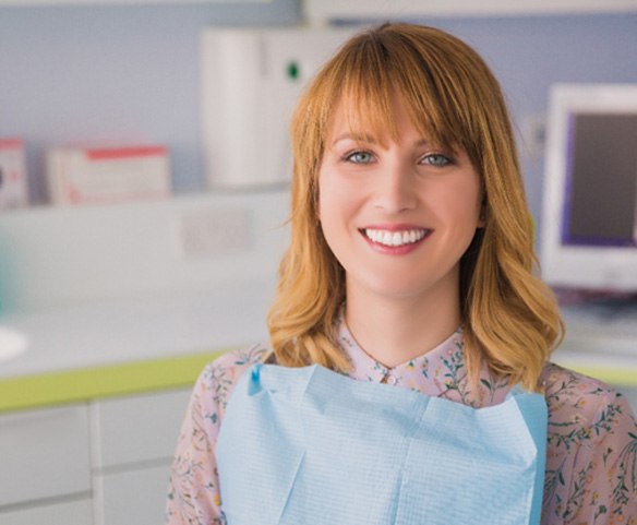 Woman smiling and waiting in a periodontist’s office