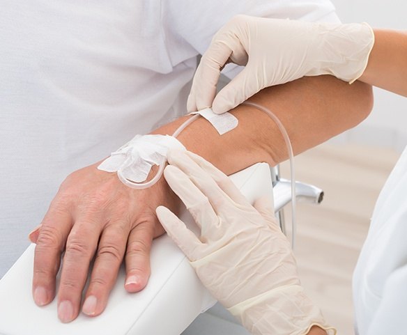 Patient with IV sedation drip in hand
