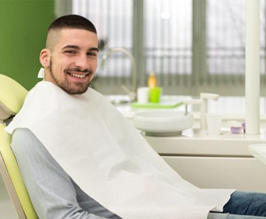 Male dental patient smiling while waiting for dentist 