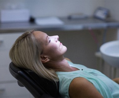 Woman leaning back in dental chair while relaxed