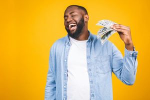 person fanning themselves with money and smiling