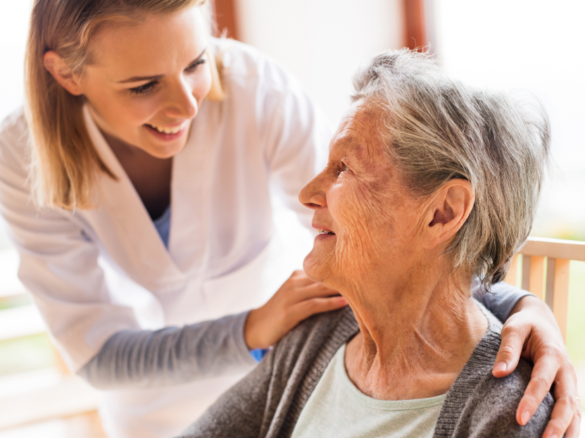 Young woman with hands on elderly woman's shoulders